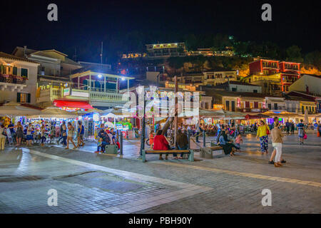 La fantastica città costiera di Parga di notte. Turisti e visitatori di camminare lungo la costa vicino alla bellissima decorata dai negozi e dai ristoranti. Parga Foto Stock