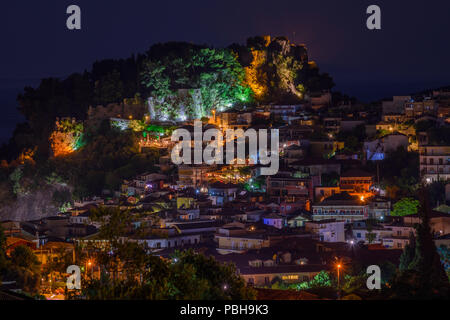 Vista aerea della pittoresca cittadina costiera di Parga illuminata di notte. Centrato lo storico castello veneziano di Parga Epiro, Grecia, Europa Foto Stock