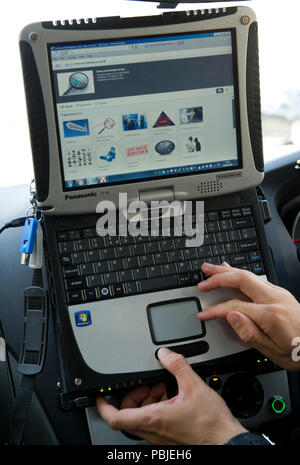 Avon & Somerset Constabulary. PC Andy Bird Patchway dalla stazione di polizia,Bristol,utilizzando il sistema informatico nella sua auto di pattuglia nella zona Patchway. Foto Stock