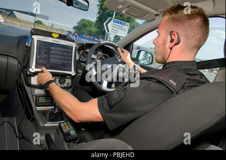 Avon & Somerset Constabulary. PC Andy Bird Patchway dalla stazione di polizia,Bristol,utilizzando il sistema informatico nella sua auto di pattuglia nella zona Patchway. Foto Stock