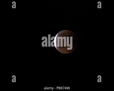 Vista la luna di sangue durante la più lunga Eclissi lunare totale del XXI secolo sul cielo nero visto dalla Polonia nel 2018 calda notte d'estate venerdì 2 luglio Foto Stock