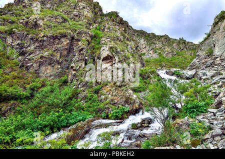 Mountain Creek con cascate sotto le scogliere tra massi in Altai mountains, Russia - bellissimo paesaggio estivo Foto Stock