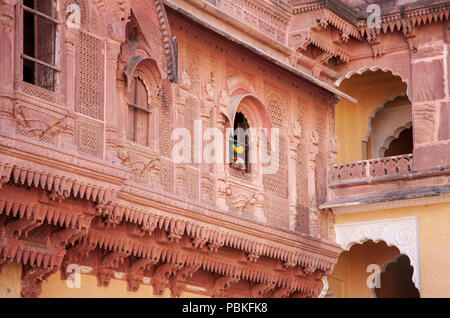 Guida indiana che indossa un turbante di guardare attraverso una finestra al Forte Mehrangarh, Jodhpur, India Foto Stock