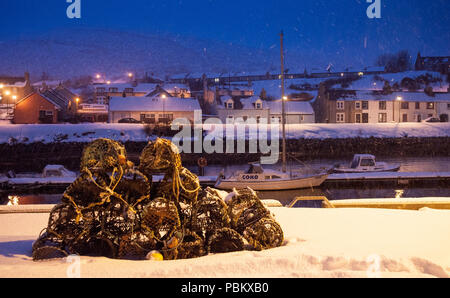 Lobster Pot giacere tra la neve sulla parete del mare di Helmsdale porto sul Moray Firth costa di Sutherland nel lontano Nord delle Highlands della Scozia. Foto Stock