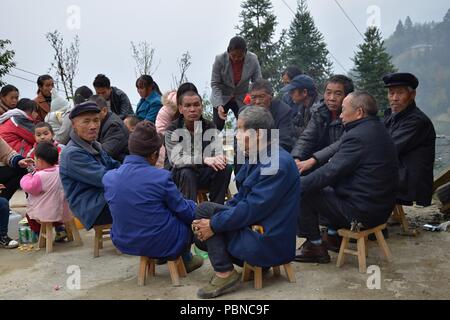 GUIZHOU, Cina - circa nel dicembre 2017: un gruppo di persone diverse minoranze etniche sedersi insieme in occasione della festa di nozze. Foto Stock