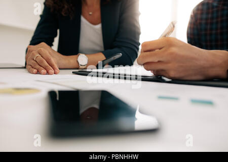 Close up mani di focalizzazione dei colleghi di lavoro in occasione di un incontro per discutere il lavoro. Imprenditrice in occasione di un incontro con un collega in ufficio. Foto Stock