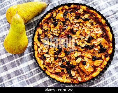 Vista superiore del rustico Crostata di pere con uvetta e mandorle a fette in teglia Foto Stock