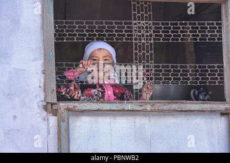 Ragazza nella finestra, Sary Mogul Bazaar, Kirghizistan Foto Stock