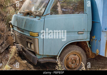 la vecchia auto viene gettata nel cestino . L'automobile abbandonata al  dumpster Foto stock - Alamy