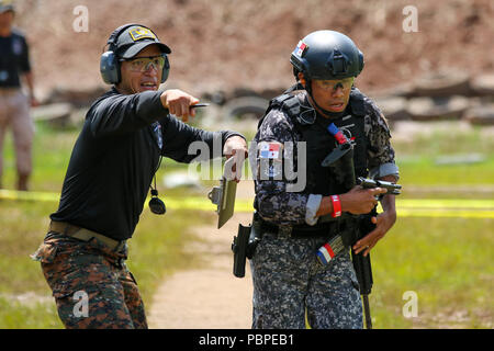 Un panamense membro del team è guidato da un giudice come egli avanza per l'ultima stazione dell'assalto evento presso Instituto Superior de la Policia Presidente Belisario Porras come parte del quinto giorno della competizione in Panama City, Panama, luglio 20. Fuerzas Comando è una multinazionale annuale speciale forze operative competenze concorso sponsorizzato da U.S. Comando Sud e ospitato quest anno dal Ministero della pubblica sicurezza, Panama. (Foto di esercito Sgt. Alexis Velez) Foto Stock