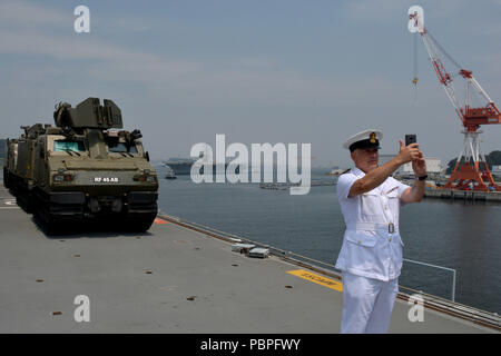 180724-N-XN177-1090 Yokosuka, Giappone - British Royal Navy Chief Petty Officer John Mackenzie prende un selfie con gli Stati Uniti La marina è distribuita portaerei USS Ronald Reagan (CVN 76) dal ponte di volo della Royal Navy Amphibious Assault nave HMS Albion (L 14) come esso ritorna negli Stati Uniti. Le attività della flotta (FLEACT) Yokosuka. FLEACT Yokosuka fornisce, mantiene e gestisce servizi di base e servizi a sostegno del settimo della flotta di inoltro distribuito le forze navali, 71 comandi di tenant, e 27.000 militari e civili. (U.S. Foto di Marina di Massa lo specialista di comunicazione 1a classe Pietro Burgha Foto Stock