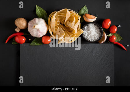 Fettuccine tagliatelle pasta e scheda di ardesia con funghi, erbe e spezie Foto Stock