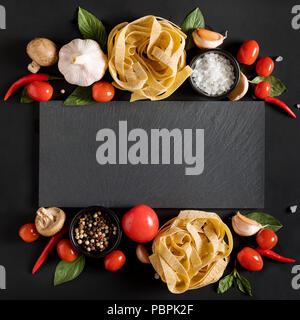 Fettuccine tagliatelle pasta e scheda di ardesia con funghi, erbe e spezie Foto Stock