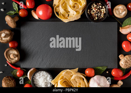 Fettuccine tagliatelle pasta e scheda di ardesia con funghi, erbe e spezie Foto Stock