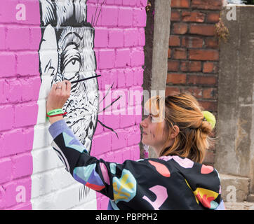 Alex di Lucas Lucas Antics lavorando sul suo dipinto murale a parete al decimo anniversario di UPFest, la vernice urbano Festival in South Bristol, Regno Unito Foto Stock