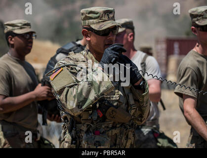 Primo Lt. Rosado Alexander, U.S. La riserva di esercito di delegato per la 348Polizia Militare Company, invita la radio mentre i soldati escort un 'nemico del prigioniero di guerra' roleplayer attraverso la loro detenzione Teatro Facility a combattere la formazione per il supporto di esercizio (CSTX) a Fort Hunter Liggett, California, 21 luglio 2018. Durante l'esercizio scenario, la polizia militare sono responsabili per un teatro fermo impianto per processi e proteggere fino a 4.000 nemico di prigionieri di guerra e anche di gestire una detenzione area di contenimento ad accogliere sfollati civili. La polizia militare dispone di una vasta gamma di responsabilità Foto Stock
