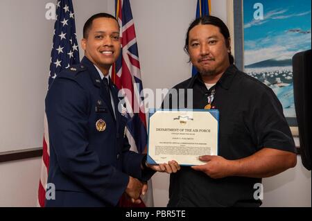 Lt. Col. Wade McGrew, XXI operazioni nello spazio comandante dello squadrone, presenta le Air Force civili Award per il valor di Jason Fukumoto, Distacco 3, XXI elettricista SOPS, al punto Kaena Satellite stazione di tracking, Hawaii, luglio 23, 2018. Due anni fa, Fukumoto fornito aiuto medico a uno stato delle Hawaii campo di volontariato membro di equipaggio che hanno sofferto a causa di inalazione di fumo durante un incendio presso il gioco Kuaokala Area di gestione. (U.S. Air Force foto di Tech. Sgt. Heather Redman) Foto Stock