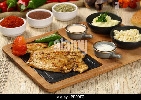 Pollo alla griglia bistecca con patate fritte e riso pilaf Foto Stock