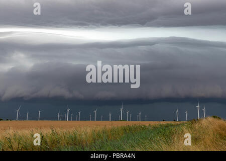 Tempesta davanti avvicinando le turbine eoliche su Romney Marsh, Kent, Inghilterra Foto Stock