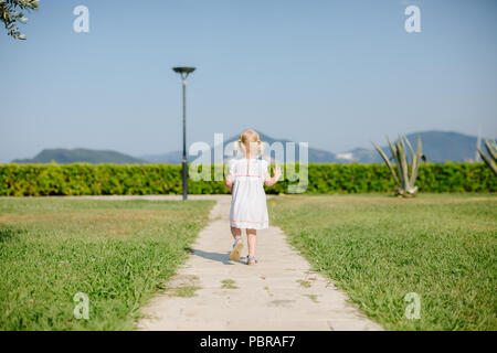 Bambina scappare. vista posteriore. Bambino non identificato Foto Stock