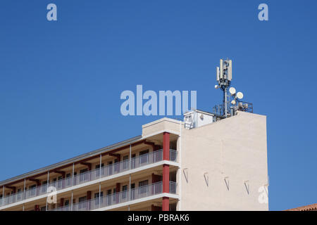 Telecomunicazioni e antenne di telefonia mobile in un tetto di un edificio Foto Stock