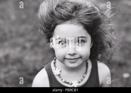 Ritratto in bianco e nero di piccolo grazioso ragazza sorridente al di fuori Foto Stock