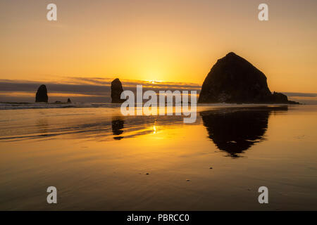 Bel tramonto oltre alla Haystack Rock, Cannon Beach, Oregon Coast, Stati Uniti d'America. Foto Stock