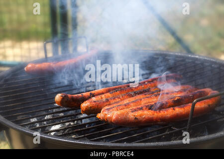 Close-up di un mazzetto di merguez salsicce tostatura su un barbecue grill. Messa a fuoco selettiva. Foto Stock