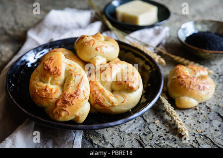 Pane appena sfornato nodi con il formaggio e il nero di semi di cumino Foto Stock