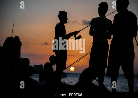 Il popolo cubano pesce al Malecon durante il tramonto,malecon è il luogo di incontro dove si possono trovare riposo, amici e un sacco di rum! Foto Stock