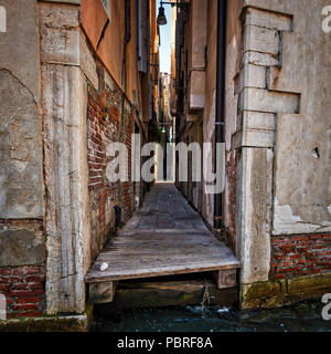 Un vicolo di passaggio tra due edifici a Venezia conduce all'accesso all'acqua Foto Stock