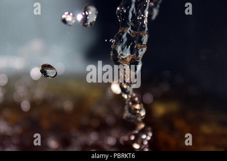 Le goccioline di acqua che colpisce la superficie Foto Stock