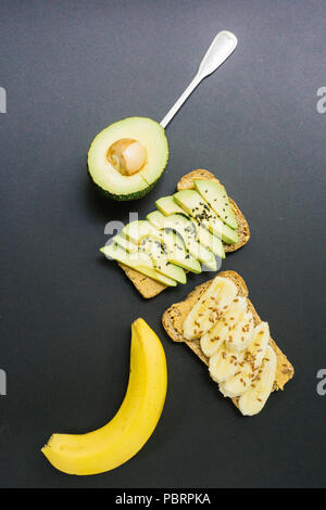 Toast con avocado, di sesamo e burro di arachidi sul grano intero pane e toast con banana e lino su tutto il pane di grano Foto Stock