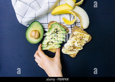 Toast con avocado, di sesamo e burro di arachidi sul grano intero pane e toast con banana e lino su tutto il pane di grano Foto Stock