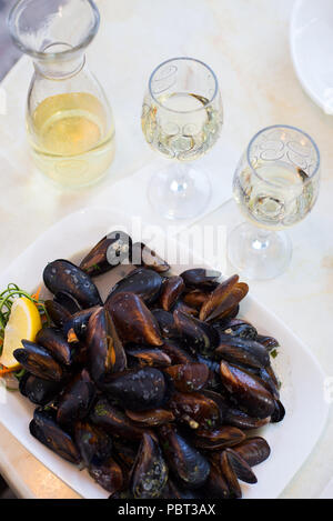 Vino bianco e le cozze in un guscio in un cafè sul tavolo Foto Stock