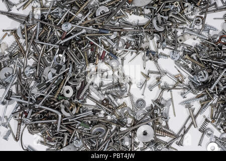 Un sacco di denti, viti, bulloni e umori su uno sfondo bianco. Foto astratte. Foto Stock