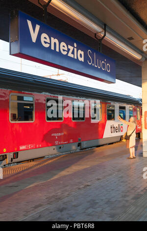 Thello per una notte di treno passeggeri tra Parigi e Venezia in Venezia S Lucia, Venezia, Veneto, Italia al tramonto . Signora anziana dire addio Foto Stock