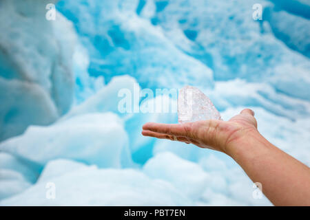 Trasparente puro pezzo di ghiaccio in mano con il ghiacciaio Svartisen, Norvegia Foto Stock