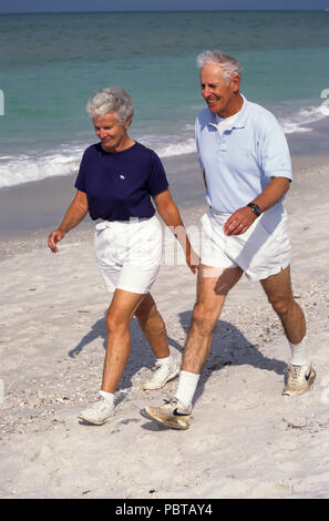 Coppia senior potenza a piedi sulla spiaggia signor © Myrleen Pearson ..Ferguson Cate Foto Stock