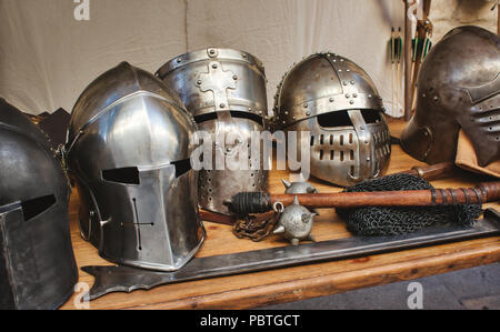 Metallo lucido caschi di cavalieri medievali con le tradizionali armi in un medioevo festival a tema Foto Stock