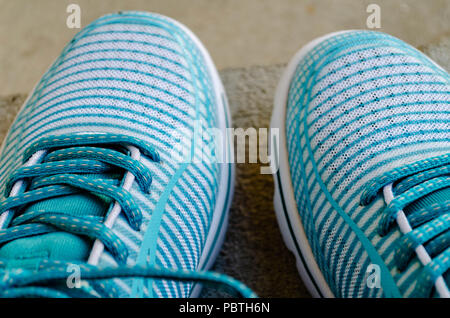 Il turchese e bianco sneakers sul marciapiede stoop Foto Stock
