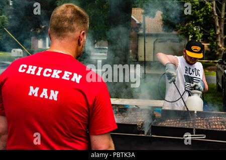 Chiesa barbecue pit crew prepara il pollo per il festival di fragola. Foto Stock