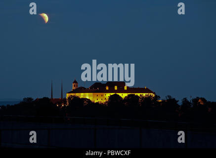 Brno, Repubblica Ceca. 27 Luglio, 2018. La luna è parzialmente coperto durante un'eclisse lunare oltre il castello di Spilberk a Brno, in Repubblica ceca, Venerdì, 27 luglio 2018. Credito: Monika Hlavackova/CTK foto/Alamy Live News Foto Stock