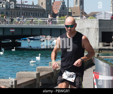 La Svizzera, 2018, Ironman Triathlon: Esecuzione di corso. Diversi concorrenti in esecuzione attraverso la città di Zurigo, Bellevue. Foto Stock