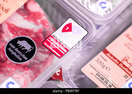 Dusseldorf, Germania. Il 30 luglio, 2018. 30.07.2018, Germania, Duesseldorf: un adesivo per informare i clienti della zootecnia è incollata sui pacchetti di carne. La Germania discount sono sempre più fornendo informazioni sulla zootecnia condizioni per i prodotti a base di carne. Catene di supermercati sono invece ancora titubante. (Sul dpa "Rewe anche mantenendo i piani di etichettatura per le carni fresche di' del 31.07.2018) Credito: Marcel Kusch/dpa/Alamy Live News Foto Stock