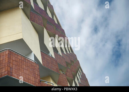 Vista dalla parte inferiore della facciata di un edificio residenziale nella città tedesca di Colonia sullo sfondo di un cielo nuvoloso Foto Stock