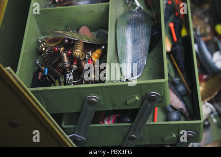 Esche Artificiali, ami da pesca e la pesca galleggianti in un Fishing Tackle Box. Foto Stock