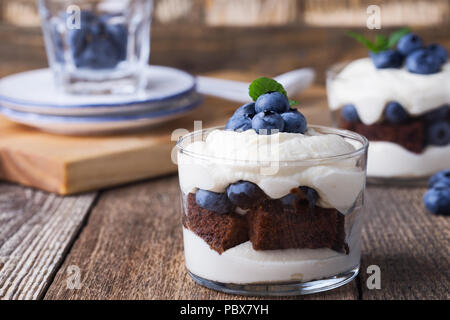 Mirtillo torta al cioccolato inezia in vetro su tavola in legno rustico, deliziosi dessert estivo Foto Stock