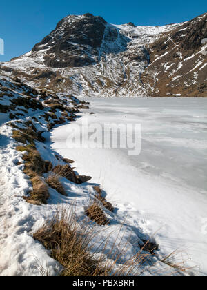 Harrison Stickle e congelati stickle tarn in inverno la neve, Langdale Pikes, Langdale, inglese Parco Nazionale del Distretto dei Laghi, Cumbria, England, Regno Unito Foto Stock