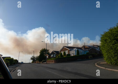 Il fumo dalla brughiera incendi sulla collina di inverno e la West Pennine Moors nasconde il cielo blu dietro le case e Rivington & Blackrod Grammar School, Giugno 2018 Foto Stock